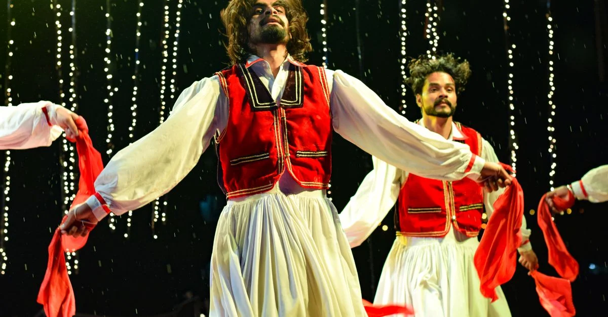 Performance de danse vibrante avec des costumes traditionnels sur scène, capturant le mouvement dynamique et l'expression culturelle.