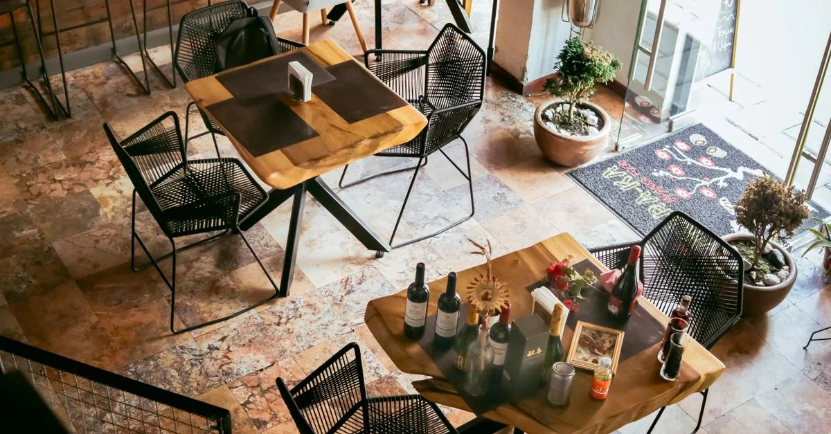 Vue aérienne de l'intérieur d'un restaurant rustique mettant en valeur une élégante décoration de table et un décor chaleureux.